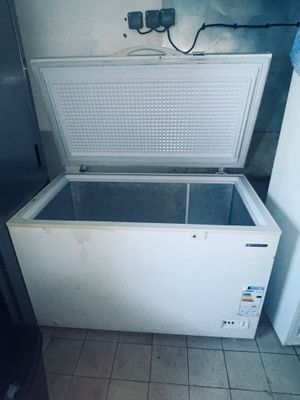 un congélateur coffre blanc posé dans le coin d'une pièce