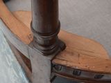 a close up of a chair with a wooden seat