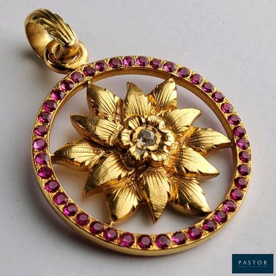 un pendentif en or orné d'une fleur au centre