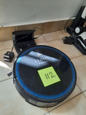 a robot that is sitting on the floor next to a bottle of wine