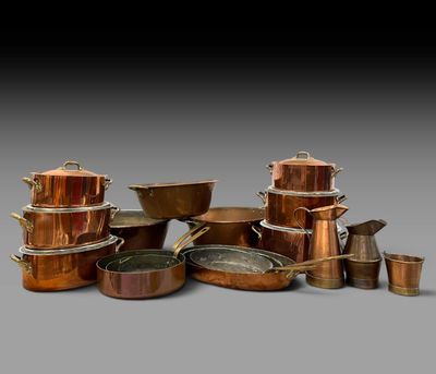 un ensemble de casseroles et poêles en cuivre empilées les unes sur les autres