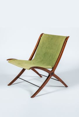une chaise verte posée sur un sol blanc