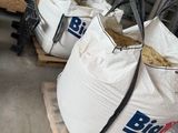 two bags of rice sitting on pallets in a warehouse