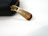 a small black purse with a gold zipper on it