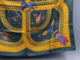 une écharpe verte et jaune ornée d'un motif représentant des oiseaux