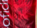 the jacket is red and white with a lot of autographs on it