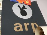 a person holding a sign that says arp in front of a pile of books