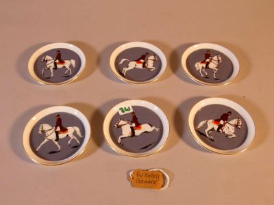six assiettes en porcelaine ornées de chevaux et de jockeys, posées sur une table