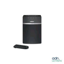 La chaîne hi-fi est noire et est équipée d'une télécommande placée à côté.