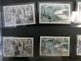 several stamps are on display in a glass case on a table