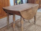 a table with a drop leaf on it in the middle of a room