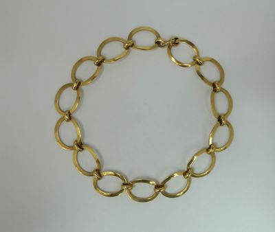 a close up of a gold chain bracelet on a white surface