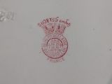 a white plate with a red crown on it