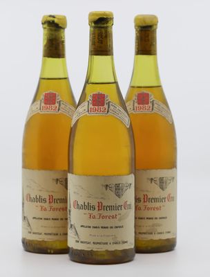 trois bouteilles de vin posées les unes à côté des autres sur une surface blanche