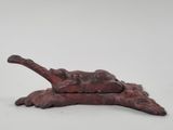 une image représentant une sculpture de chat allongé sur une branche d'arbre