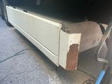 an image of a truck that has been painted white and has rust on the side of it