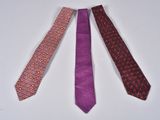 three different colored ties laid out on a white surface