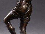 statue of a man holding a tennis racquet on a marble base