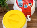 un récipient en plastique muni d'un couvercle jaune, posé sur une table en bois
