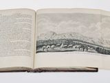 an open book with a picture of a mountain in the background
