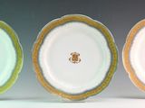 three plates with gold rims are sitting side by side on a white surface
