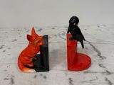 deux figurines représentant un chat et un oiseau posées sur une table