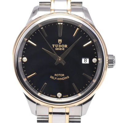 the black dial of a watch is displayed against a white background