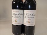 two bottles of red wine sitting on a counter