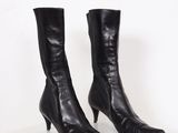a pair of black leather boots on a white surface