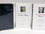 three books are lined up on a white surface next to each other