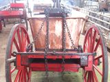 a red wagon with a metal bucket attached to it