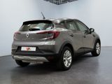 the rear end of a grey car in a large room