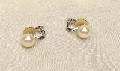 two pairs of pearl earrings on a white cloth