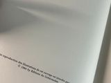 a person holding a book open on a table