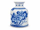 un vase bleu et blanc posé sur une surface blanche