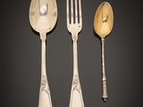 three silver spoons and a fork on a black surface