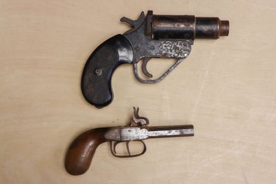 two old guns that are on a wooden table