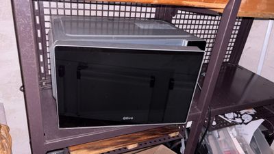 a microwave sitting inside of a metal cabinet in a room