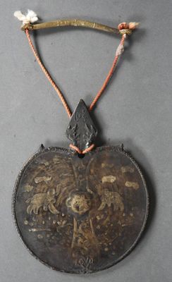 un pendentif noir et doré orné d'un oiseau
