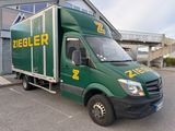 a green delivery truck parked in front of a building