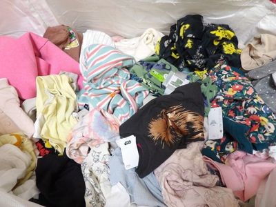 une pile de vêtements posée sur un lit
