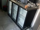 a picture of a kitchen with a refrigerator and two monitors