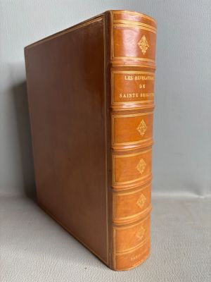 a brown leather book sitting on top of a table next to a wall