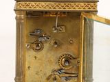 a gold clock with a glass case on it