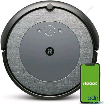 un gros plan d'un aspirateur robot muni d'un bouton vert