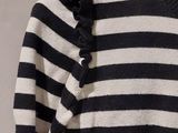 a black and white striped sweater with ruffles on it
