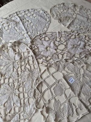 une table recouverte d'une nappe blanche sur laquelle est posé un napperon
