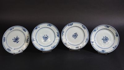 quatre assiettes bleues et blanches ornées de fleurs sur un fond noir