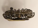 a metal object that is sitting on a white surface