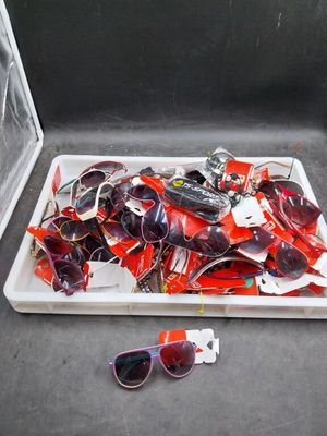a tray of sunglasses and a pair of sunglasses on the floor
